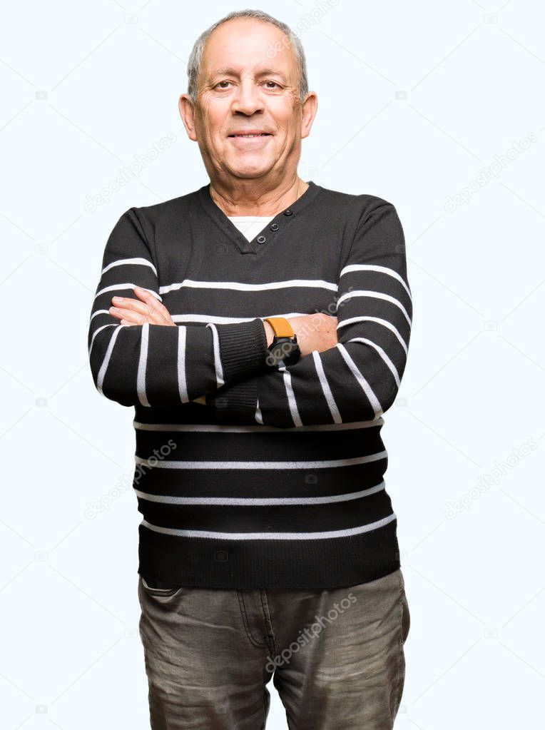 Handsome senior man wearing winter stripes sweater happy face smiling with crossed arms looking at the camera. Positive person.