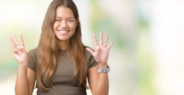 Genç güzel esmer kadın gösterilen ve parmakları ile işaret izole arka plan yüzünden kendinden emin ve mutlu gülümseyerek süre sekiz numara.