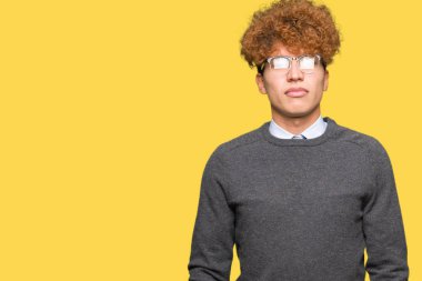 Genç yakışıklı iş adamı afro saçlı gözlüklü ciddi ifade ile yüzünde. Basit ve doğal kameraya bakıyor.