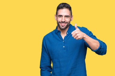 Yakışıklı delikanlı hareketi el ile mutlu yaşasın yapıyor izole arka plan üzerinde. Başarı gösteren kameraya bakarak ifade onaylama.