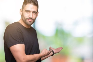 Açık el ile doğal gülümseyen girmek için davet izole arka plan üzerinde genç yakışıklı adam