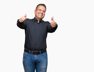 Yakışıklı orta yaş Arap iş adamı el ile pozitif jest yapıyor onaylama izole arka plan üzerinde başparmak gülümseyen ve başarı için mutlu. Kamera, kazanan jest arıyorsunuz.