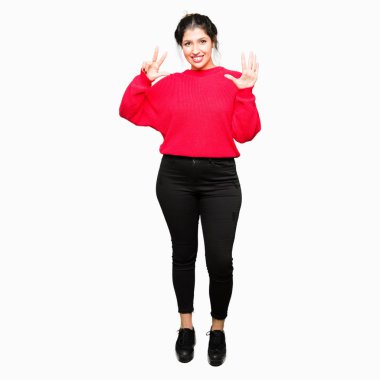 Genç güzel kadın kırmızı kazak ve topon gösteren giyen ve parmakları ile işaret ederken emin ve mutlu gülümseyerek sekiz numara.