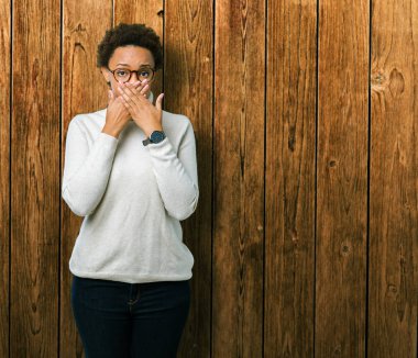 Genç güzel Afrikalı-Amerikalı kadın üzerinde gözlük takan arka plan ağız hata için elleriyle kapsayan şok izole. Gizli kavramı.