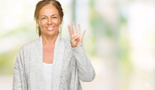 stock image Beautiful middle age adult woman wearing winter sweater over isolated background showing and pointing up with fingers number four while smiling confident and happy.