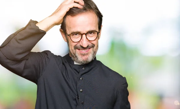 カトリックのローブを着た中年の司祭の男は 質問について混乱し 不思議に思います 頭の上に手を置いて考え 疑いを持って不確か ペンシブコンセプト — ストック写真