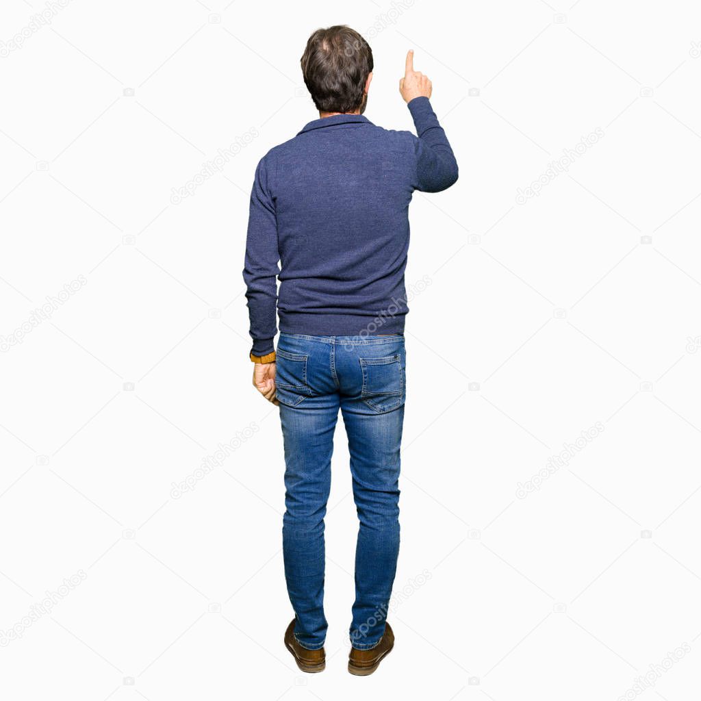 Middle age handsome man wearing a sweater Posing backwards pointing behind with finger hand