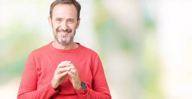 Arka plan eller üzerinde kış kazak giymiş yakışıklı orta yaş ağarmış komuta sizde birlikte izole ve rahat ve neşeli gülümseyen parmak çarpı işareti. Başarı ve iyimser