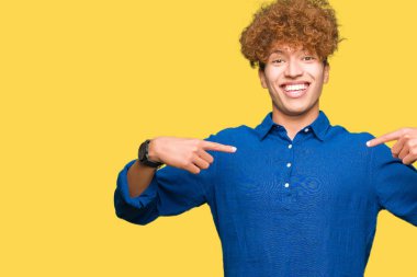 Yüzünde gülümseme ile kendinden emin görünüyorsun, kendini gururlu ve mutlu parmakları ile işaret afro saçlı Genç yakışıklı zarif adam.