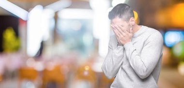 Genç yakışıklı adam üzgün ifade yüz eller ile ağlayarak süre kapsayan ile izole arka plan üzerinde kazak giyiyor. Depresyon kavramı.