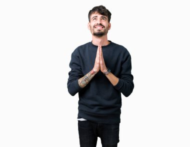 Yakışıklı delikanlı yalvarıyor ve umut ifade yüzünde çok duygusal ve endişe ile birlikte elleriyle dua izole arka plan üzerinde. Bağışlanmak. Din kavramı.