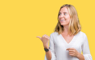 Seyir ve başparmak yanında yukarıyı mutlu yüz ile gülümseyen izole arka plan güzel genç zarif kadın.