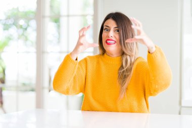 Evde kışlık kazak giyen genç güzel kadın öfkeden bıkmış bağırıyor, elleri boğmaya çalışıyor, deli diye bağırıyor