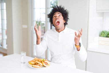 Afro-Amerikan aç adam öğle yemeği için hamburger yemek deli ve deli bağırarak ve agresif ifade ve kollar kaldırdı ile bağırıyor. Hayal kırıklığı kavramı.