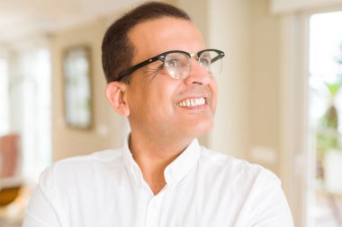 Evde kameraya gülümseyen gözlük takan orta yaş erkek