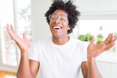 Afrikalı-Amerikalı dostum deli ve çığlık kaldırdı ve açık gözleri heyecanlı silah ile başarı için hayran kutluyor gözlük takıyorsun. Kazanan kavramı