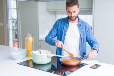 Evde makarna pişiren yakışıklı adam.