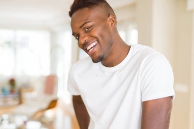 Büyük bir gülümseme ile neşeli gülümseyen yakışıklı Afrikalı genç adam 