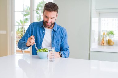 Yakışıklı adam evde yeşil bezelye yeme