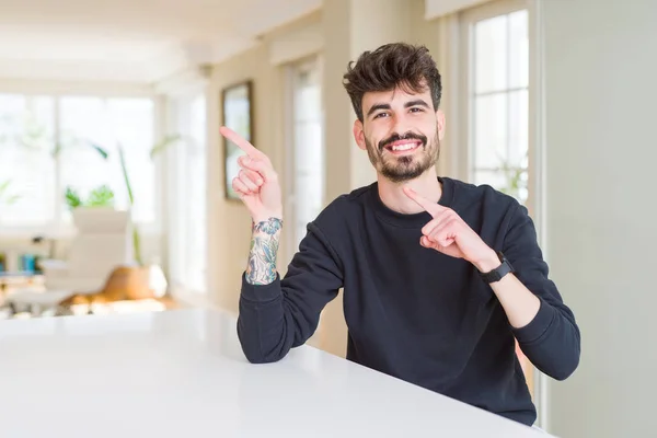 Hombre Joven Con Sudadera Casual Sentado Una Mesa Blanca Sonriendo — Foto de Stock