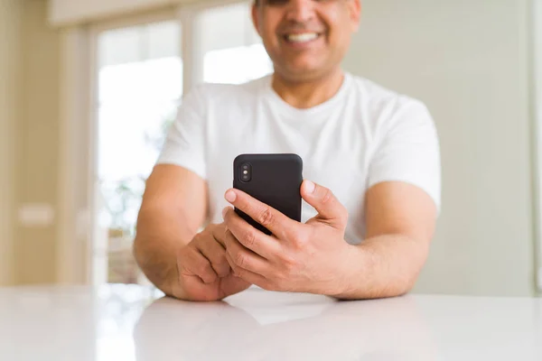 Primer plano de las manos de hombre de mediana edad utilizando el teléfono inteligente en casa —  Fotos de Stock