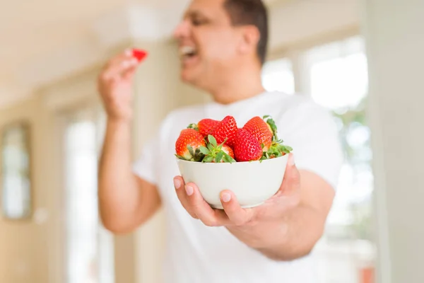 Middle age man eating strawberry at home — Stock Photo, Image