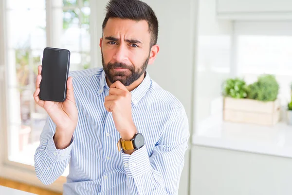 Yakışıklı Spanyol Adamı Akıllı Telefon Ekranı Gösteren Ciddi Yüz Soru — Stok fotoğraf