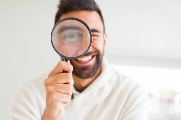 Schöner Mann mit Lupe und lustigen Gesichtern — Stockfoto