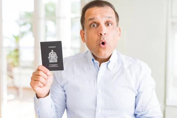 Mężczyzna Średnim Wieku Gospodarstwa Gospodarstwa Kanadyjski Paszport Przestraszony Szoku Niespodzianką — Zdjęcie stockowe