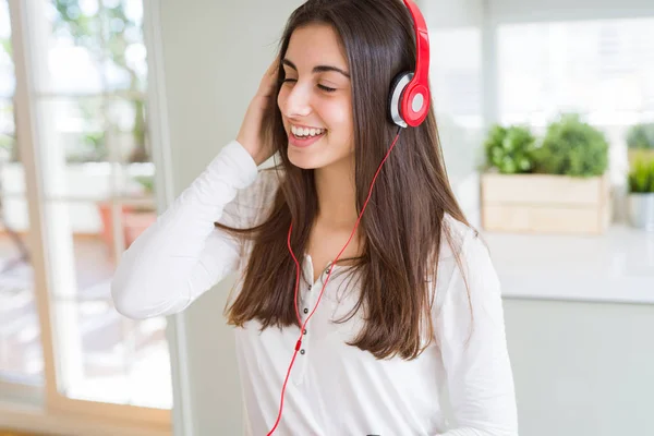 Hermosa mujer joven con auriculares escuchando música, enj — Foto de Stock