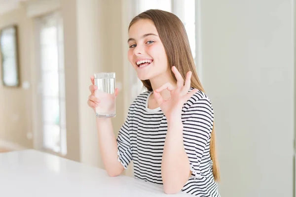 指でOkサインをやって水の新鮮なガラスを飲む美しい若い女の子の子供 優れたシンボル — ストック写真