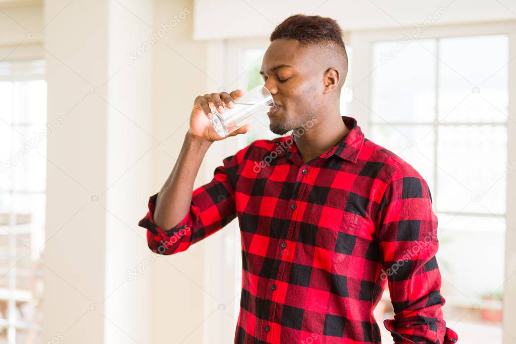 Young african american man drinking a fresh glass of water