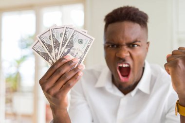 Afro-amerikan adam elli dolar banka banknotları tutan kızgın ve sinirli öfke, deli ve yükseltilmiş el, öfke kavramı ile bağırıyor