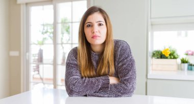 Evde güzel genç kadın şüpheci ve sinir, kesişen silah ile yüz üzerinde ifade onaylamaz. Negatif kişi.