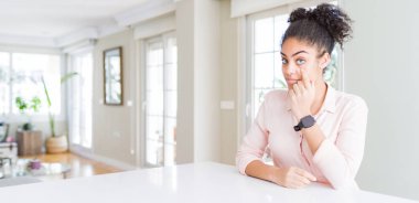 Afro saçlı güzel Afro-Amerikan kadının geniş açılı görüntüsü. Gözünü dikip jestini izliyor. Şüpheli bir ifade.