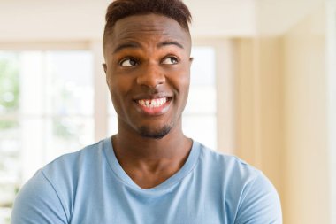 Büyük bir gülümseme ile neşeli gülümseyen yakışıklı Afrikalı genç adam 