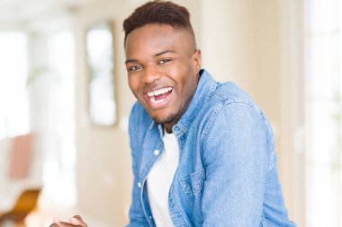 Büyük bir gülümseme ile neşeli gülümseyen yakışıklı Afrikalı genç adam 