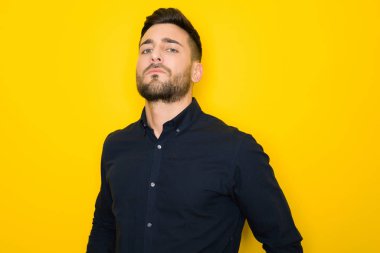 Genç yakışıklı adam possing ve modelleme sarı izole bac üzerinde