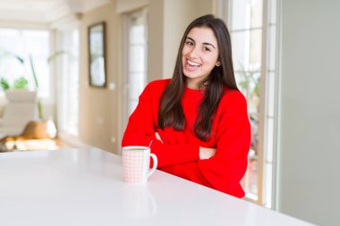 Güzel genç kadın siyah kahve mutlu yüz bir fincan içme kameraya bakarak çapraz kolları ile gülümseyerek. Pozitif kişi.