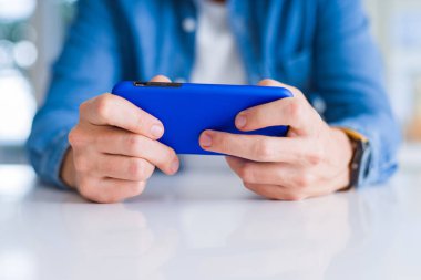 Smartphone kullanarak ve gülümseyen adam elinde yakın çekim