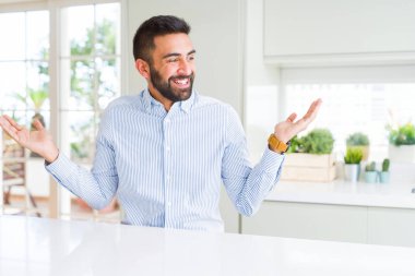 Yakışıklı İspanyol iş adamı Gülümseyen her iki elaçık avuç içi gösteren, sunan ve reklam karşılaştırma ve denge