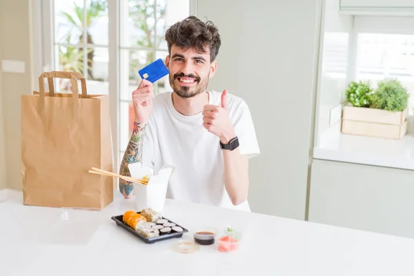 Joven Comiendo Sushi Asiático Entrega Domicilio Usando Tarjeta Crédito Como — Foto de Stock