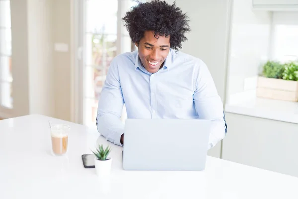 アフリカ系アメリカ人ビジネスの男性が立っていると自信を持って歯を見せて笑顔で笑っている幸せそうな顔でノート パソコンを使用しての作業 — ストック写真