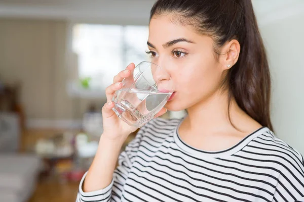 Hermosa joven bebiendo un vaso de agua fresca en casa — Foto de Stock