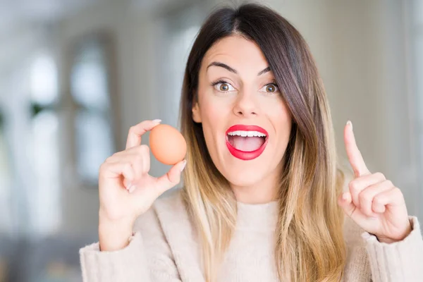 Young Beautiful Woman Holding Fresh Egg Home Surprised Idea Question — 스톡 사진