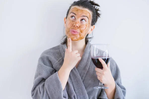 Vacker Kvinna Klädd Kosmetisk Ansiktsmask Som Hudvård Behandling Dricksglas Vin — Stockfoto