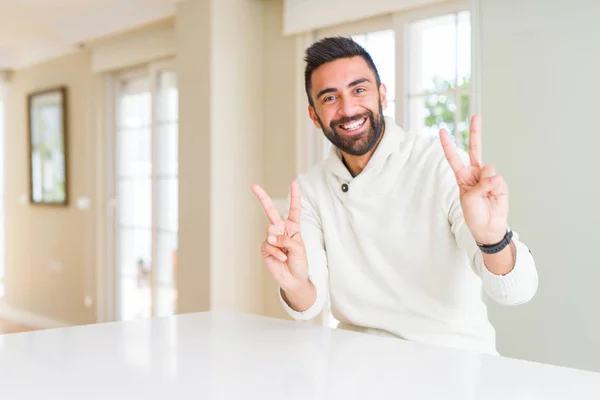 Yakışıklı Spanyol Adam Evde Rahat Beyaz Kazak Giyen Gülümseyerek Kameraya — Stok fotoğraf