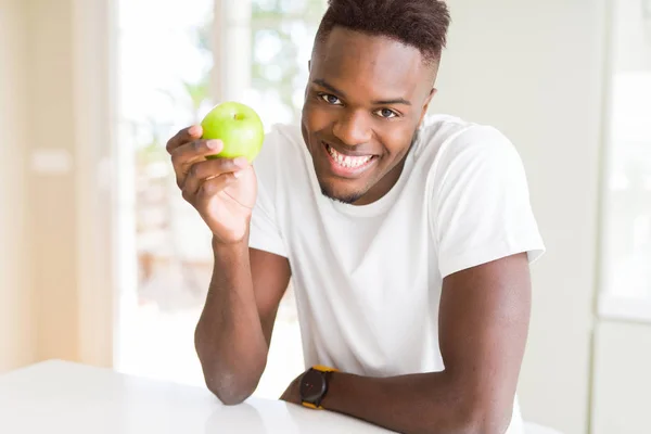 Mladý Američan Afričana muž jíst zdravé zelené jablko — Stock fotografie