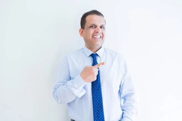 Hombre de negocios de mediana edad sonriendo y señalando hacia el costado — Foto de Stock