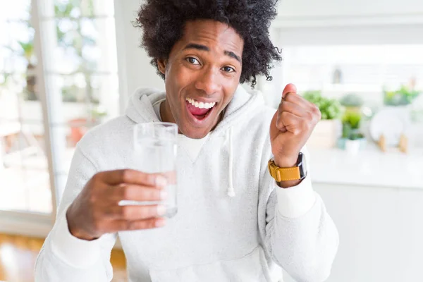 Uomo Afroamericano Che Beve Bicchiere Acqua Casa Urlando Orgoglioso Celebrando — Foto Stock